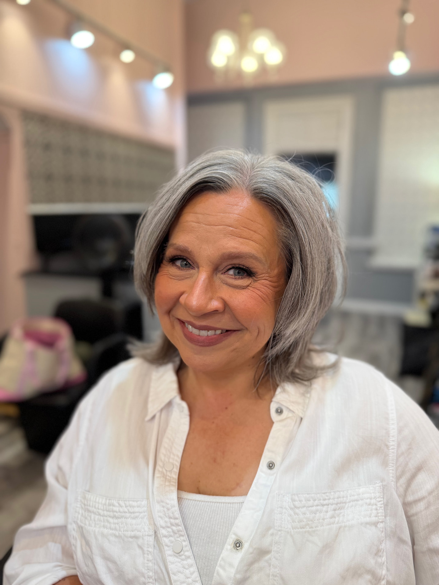 Mature client with silver hair, soft warm eye makeup, radiant skin and mauve lip