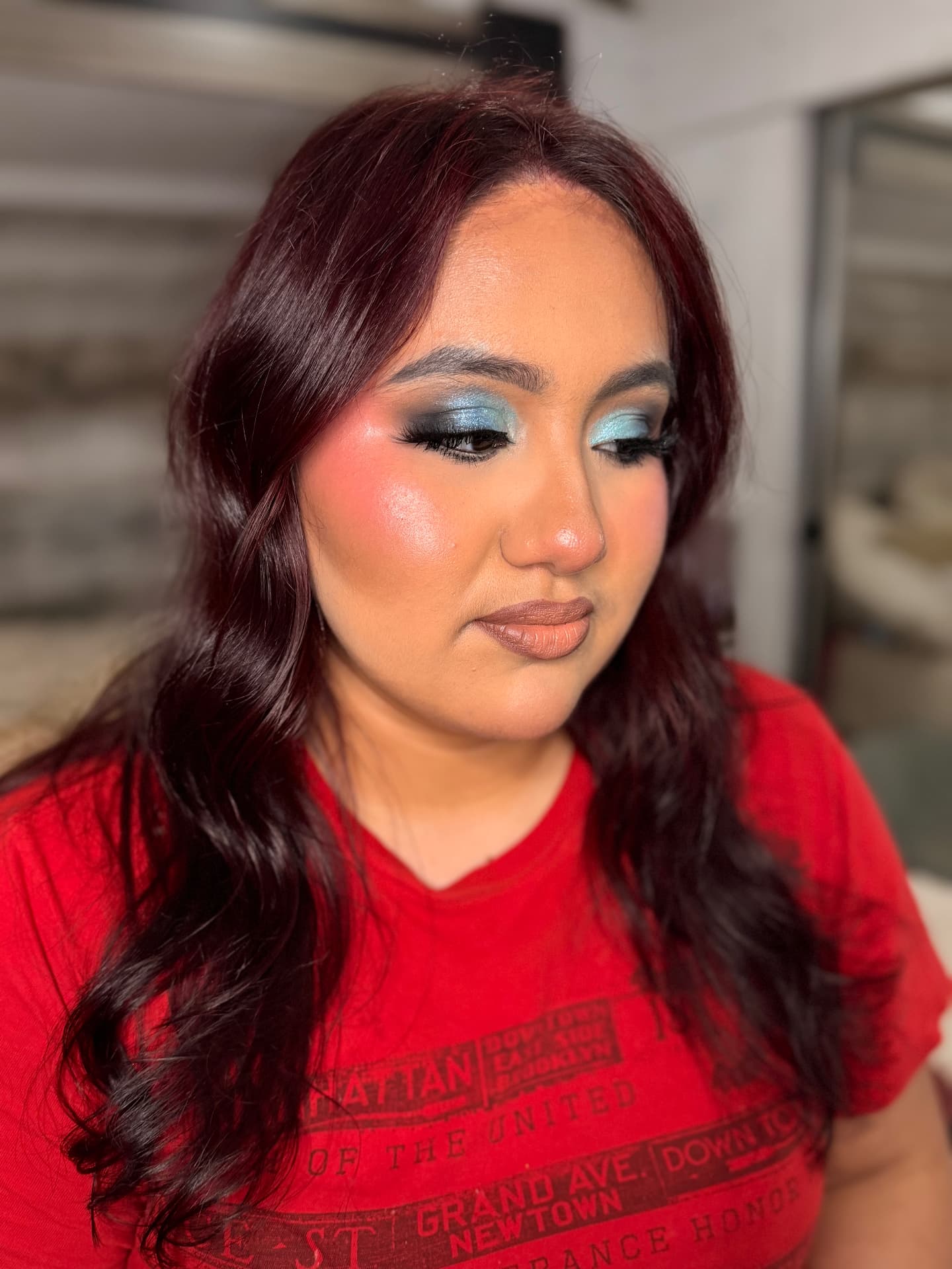Editorial teal and blue shimmer eye with coral blush and nude lip